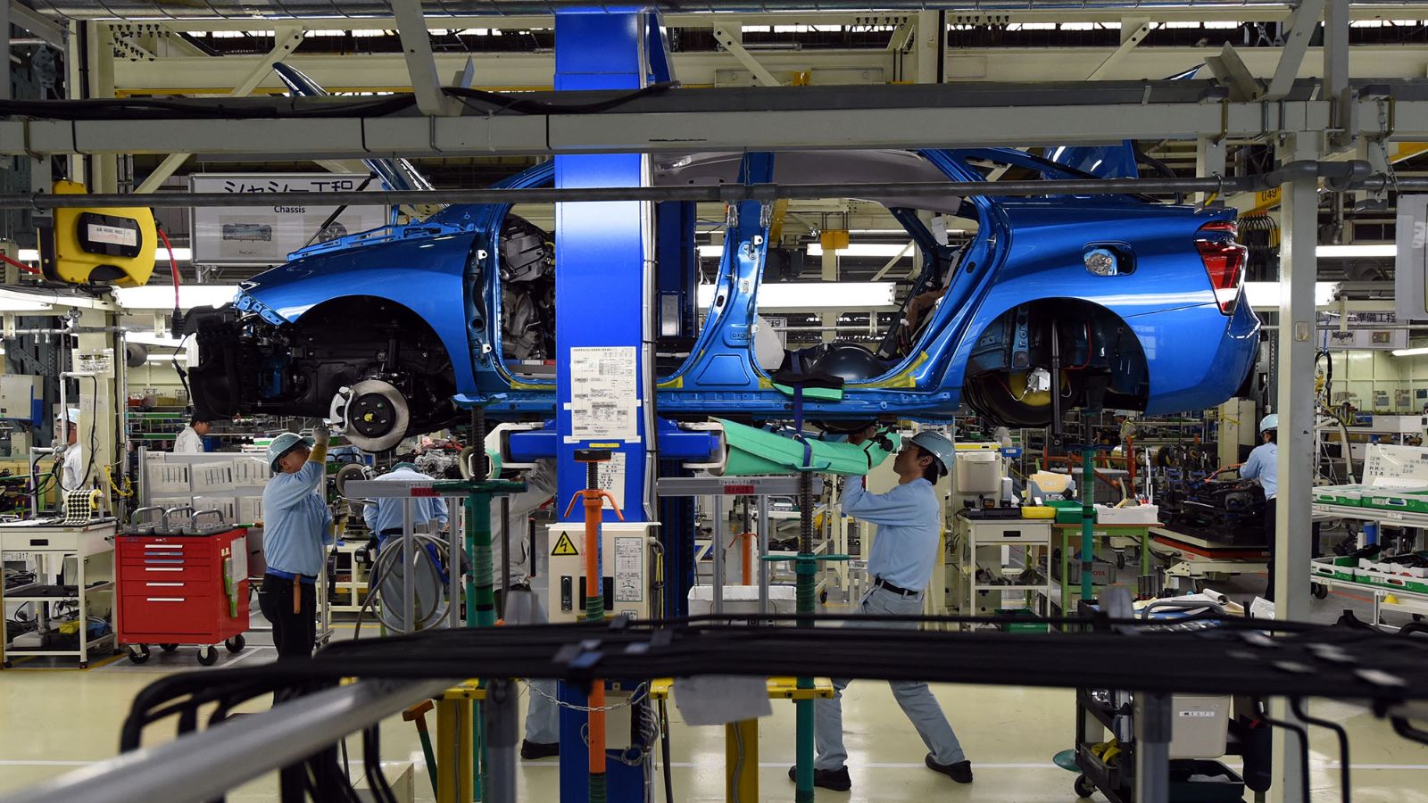 Employees of Toyota Motors assemble the FCV "Mirai" on the assembly line during the vehicle's line off ceremony at the Motomachi factory in Toyota city, Aichi prefecture on February 24, 2015. The world's biggest carmaker plans to produce 700 units of the four-door Mirai sedan -- powered by hydrogen and emitting nothing but water vapour from its tailpipe -- by the end of December. AFP PHOTO / TOSHIFUMI KITAMURA (Photo by Toshifumi KITAMURA / AFP)