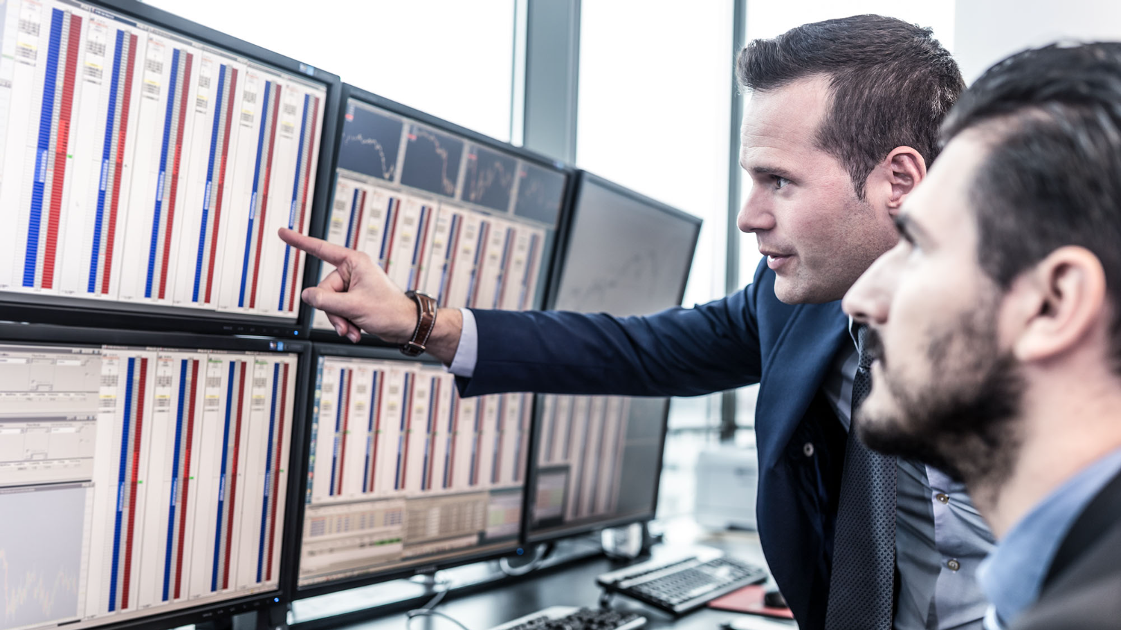 tőkepiac Businessmen trading stocks. Stock traders looking at charts, indexes and numbers on multiple computer screens. Colleagues in discussion in traders office. Broker pointing on market data on monitor., politikus
