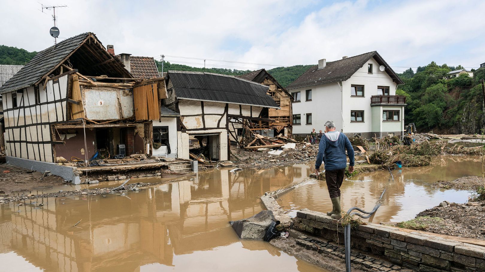 A man walks through the floods towards destroyed houses in Schuld near Bad Neuenahr, western Germany, on July 15, 2021. - Heavy rains and floods lashing western Europe have killed at least 42 people in Germany and left many more missing, as rising waters led several houses to collapse. (Photo by Bernd LAUTER / AFP)