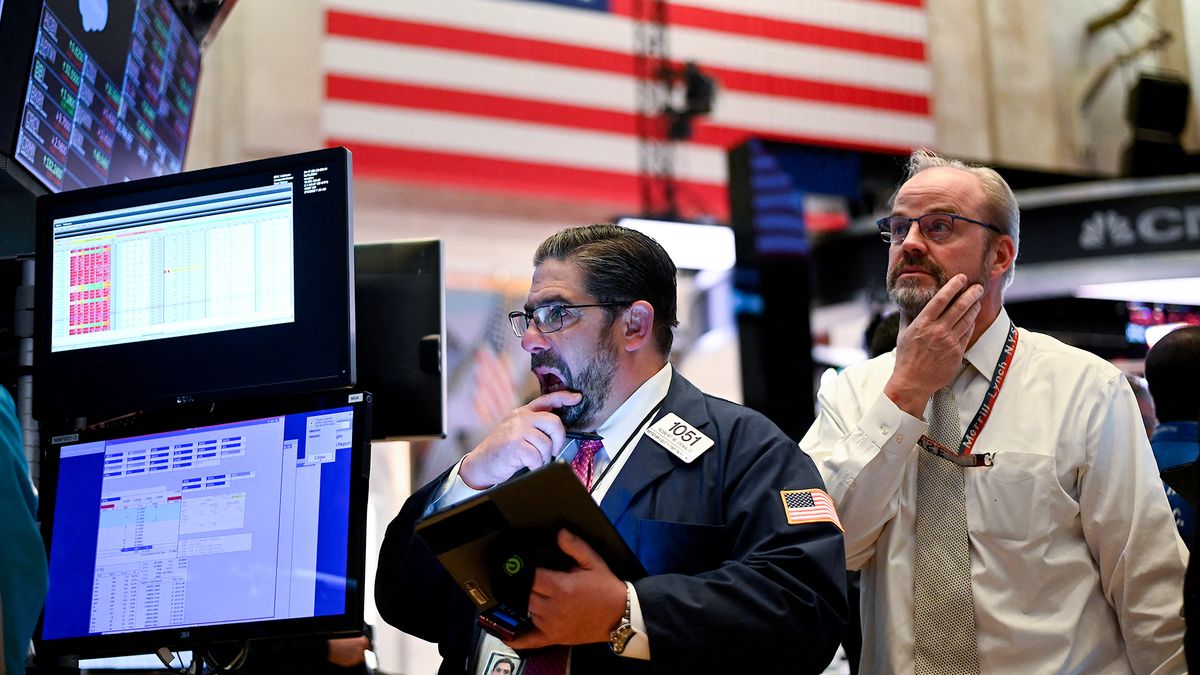 Traders work during the closing bell at the New York Stock Exchange (NYSE) on March 18, 2020 at Wall Street in New York City. - Wall Street stocks plunged again March 18, 2020 as the economic toll from the coronavirus mounts and economists warn of a deep recession.The Dow Jones Industrial Average tumbled 6.3 percent, or more than 1,300 points, to close the day at 19,903.50. The index sank by as much as 10 percent earlier in the session, which saw trading halted yet again. (Photo by Johannes EISELE / AFP)