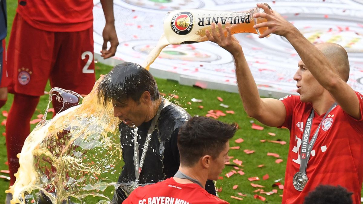 Bayern Munich's Dutch midfielder Arjen Robben (R) pours beer over Bayern Munich's Croatian headcoach Niko Kovac as Bayern Munich's Polish forward Robert Lewandowski (C), holds the trophy after the German First division Bundesliga football match FC Bayern Munich v Eintracht Frankfurt in Munich, southern Germany,  on May 18, 2019. (Photo by Christof STACHE / AFP) / DFL REGULATIONS PROHIBIT ANY USE OF PHOTOGRAPHS AS IMAGE SEQUENCES AND/OR QUASI-VIDEO