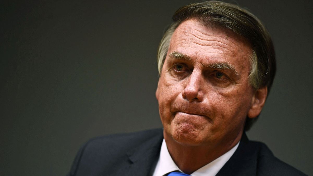 (FILES) In this file photo taken on October 22, 2021 Brazilian President Jair Bolsonaro gestures during a press conference with his Economy Minister Paulo Guedes (out of frame) at the Ministry's headquarters in Brasilia. - A Brazilian Senate commission approved a damning report on October 26, 2021 that recommends criminal charges be brought against President Jair Bolsonaro, including crimes against humanity, for his Covid policies. (Photo by EVARISTO SA / AFP)