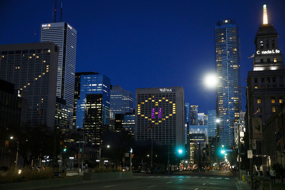 A heart is lit up in a Hilton Hotel in downtown Toronto in support of healthcare workers, as seen near hospital row on University St. on April 19, 2020, amid the novel coronavirus pandemic. - The worldwide death toll from the novel coronavirus pandemic rose to 164,016 on April 19, according to a tally from official sources compiled by AFP at 1900 GMT. (Photo by Cole BURSTON / AFP)