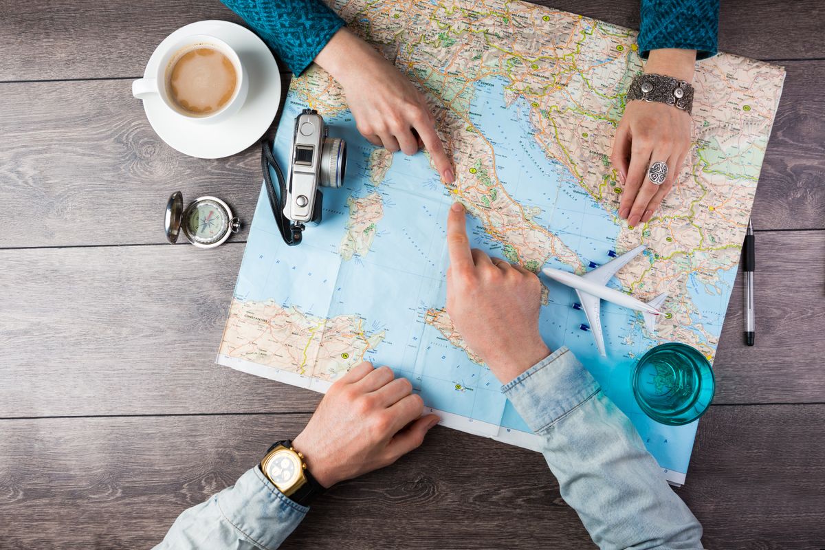 Young,Couple,Planning,Honeymoon,Vacation,Trip,With,Map.,Top,View.