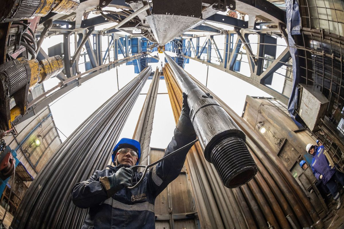 A worker guides drilling pipes at a gas drilling rig on the Gazprom PJSC Chayandinskoye oil, gas and condensate field, a resource base for the Power of Siberia gas pipeline, in the Lensk district of the Sakha Republic, Russia, on Wednesday, Oct. 13, 2021. European natural gas futures declined after Russia signaled that it may offer additional volumes soon. Photographer: Andrey Rudakov/Bloomberg via Getty Images 1235892516