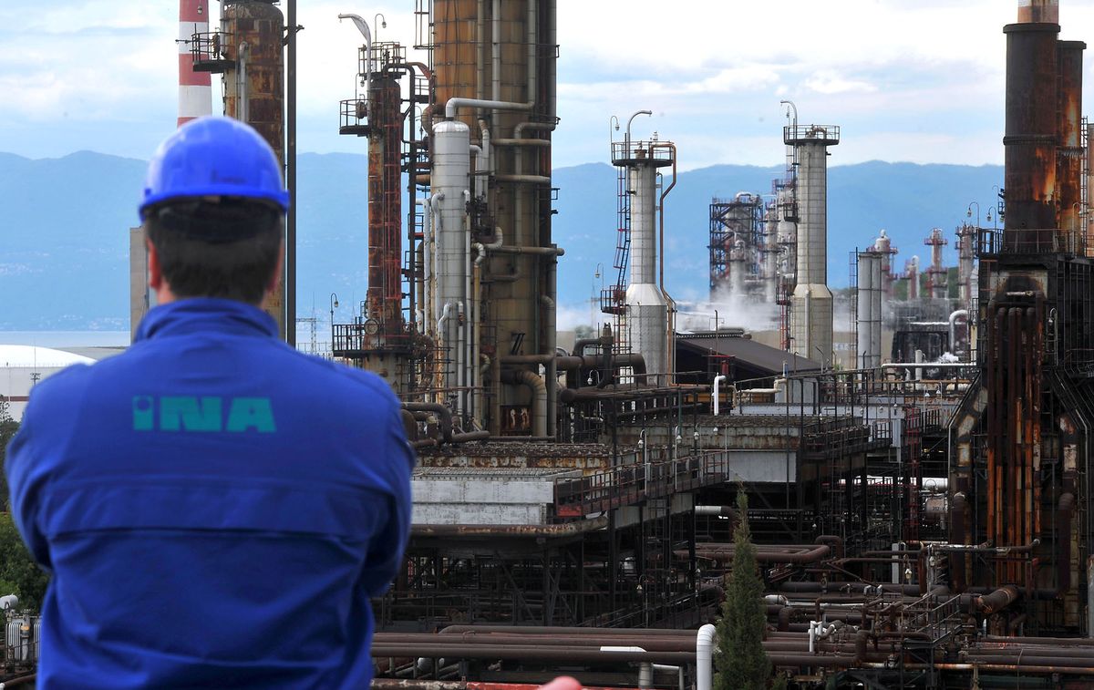 An employee looks towards refining towers at the INA Industrije Nafte d.d. oil refinery on the shores of the Adriatic sea in Urinj, near Rijeka, Croatia, on Thursday, May 23, 2013. Croatia, whose economic development was stifled by Europe's bloodiest fighting since World War II, is trying to revive growth after four years of recession or stagnation. Photographer: Oliver Bunic/Bloomberg via Getty Images 169398601
