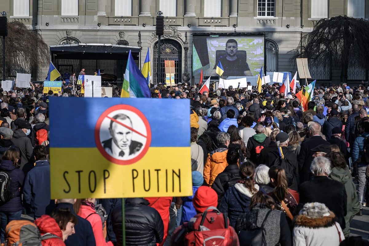 Ukrainian President Volodymyr Zelensky is displayed on a giant screen after delivering a live voice message during a demonstration against the Russian invasion of Ukraine in front of the Swiss House of Parliament in Bern, on March 19, 2022. (Photo by Fabrice COFFRINI / AFP)