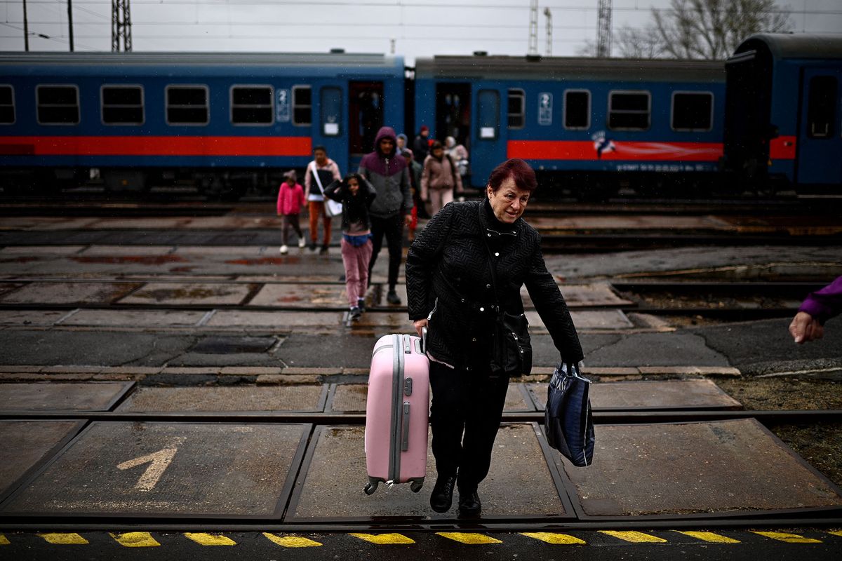 Ukrainian refugees carry their luggage upon their arrival by train at the Zahony train station after crossing the Ukrainian-Hungarian border into Hungary at the Zahony border crossing, eastern Hungary on April 9, 2022. (Photo by Christophe ARCHAMBAULT / AFP)