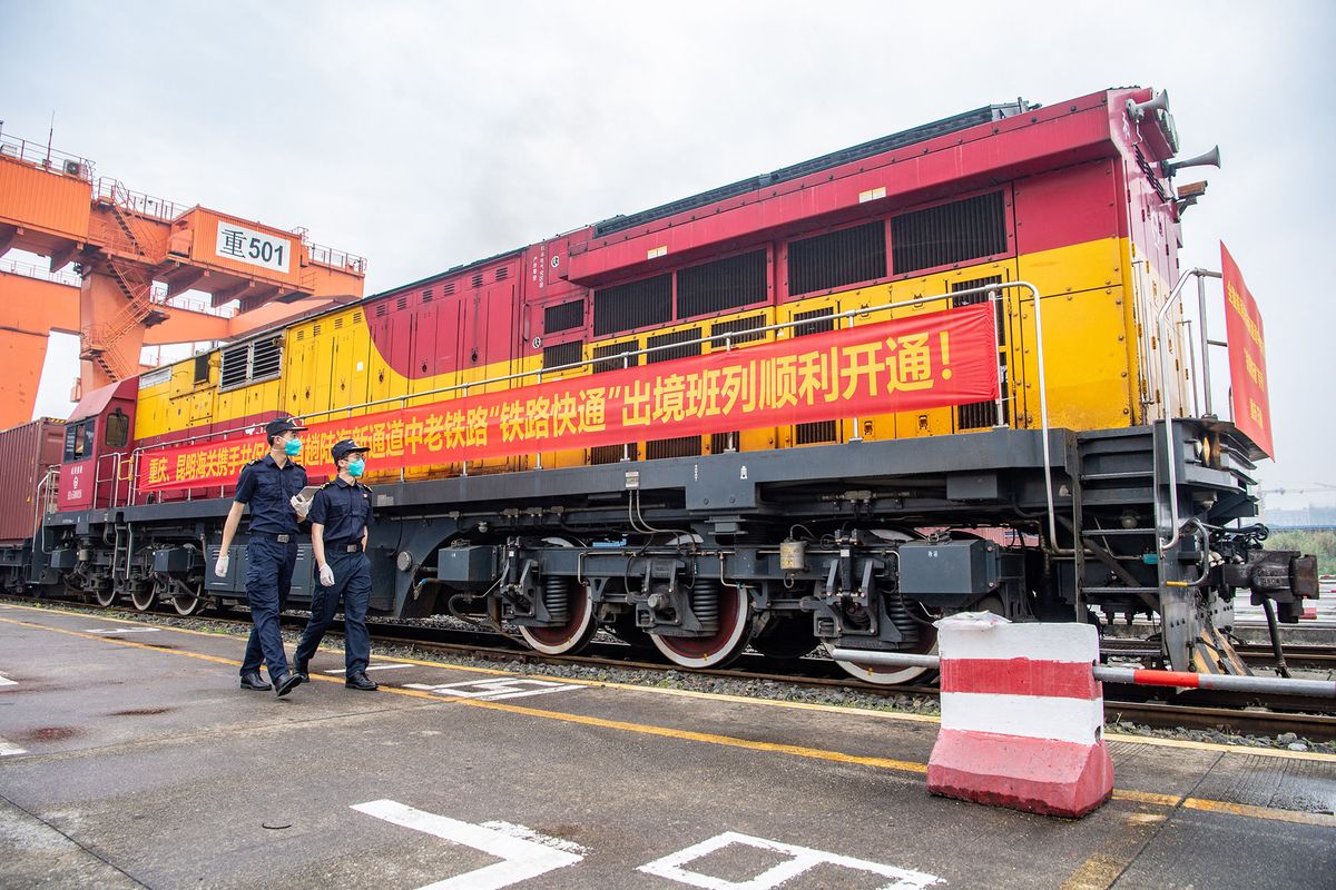 (220521) -- CHONGQING, May 21, 2022 (Xinhua) -- Customs officers inspect a China-Laos cargo train before its departure in southwest China's Chongqing Municipality, May 21, 2022. A cargo train carrying local foods and agricultural machines departed from a station in southwest China's Chongqing Municipality for Laos' capital Vientiane on Saturday, marking the launch of the first China-Laos cargo train that enjoys a favorable quick entry and export channel.   The quick entry and export channel save 24 hours in cargo clearance process, which helps shorten the journey time for freight transportation. (Xinhua/Tang Yi) (Photo by Tang Yi / XINHUA / Xinhua via AFP)