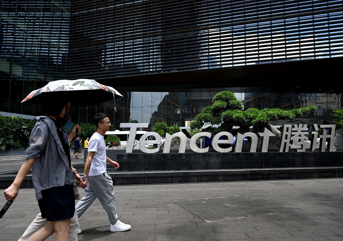 This photo taken on May 26, 2021 shows people walking past the Tencent headquarters in the southern Chinese city of Shenzhen, in Guangdong province. (Photo by NOEL CELIS / AFP)