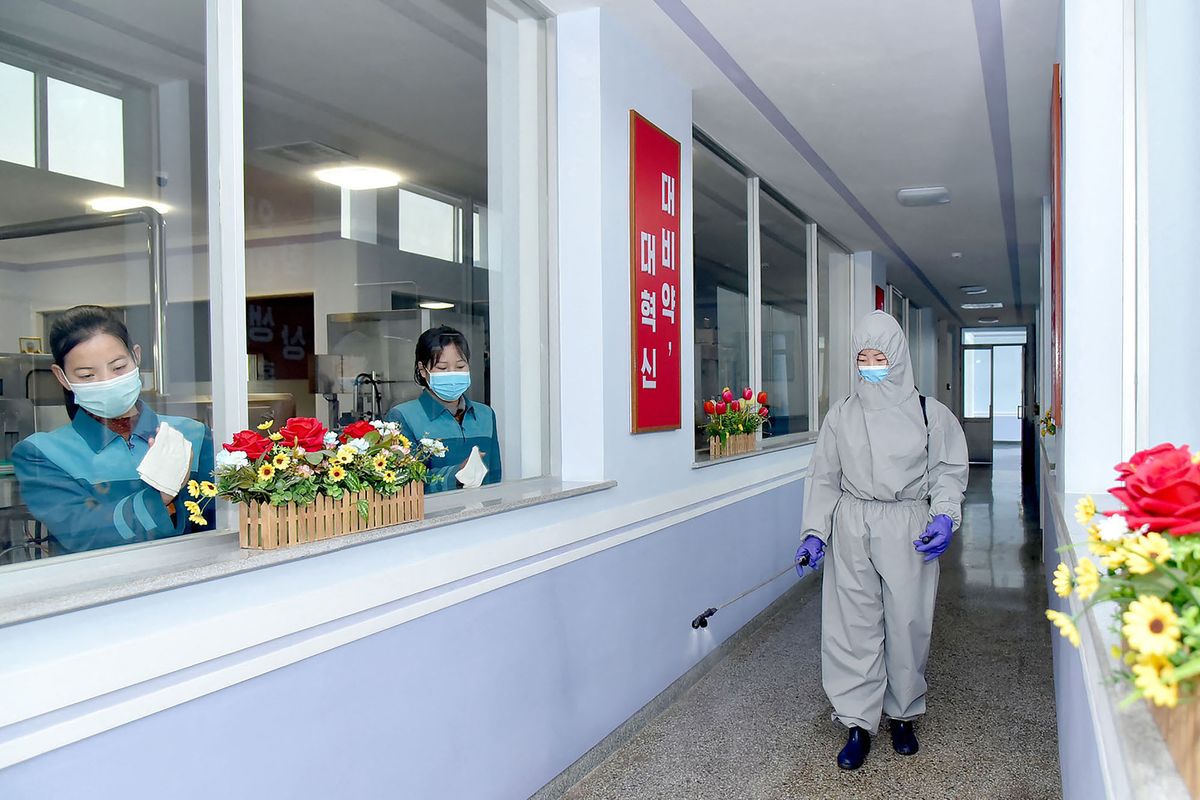 (FILES) In this file photo taken on March 20, 2021 an undated picture released from North Korea's official Korean Central News Agency (KCNA) on April 6, 2021 shows employees of the Daesongsan Mineral Water Factory in Pyongyang disinfecting the facility as a quarantine measure against the new coronavirus infection. - North Korea on May 12, 2022 confirmed its first-ever case of Covid-19, with state media declaring it a "severe national emergency incident" after more than two years of purportedly keeping the pandemic at bay. (Photo by KCNA VIA KNS / AFP)
