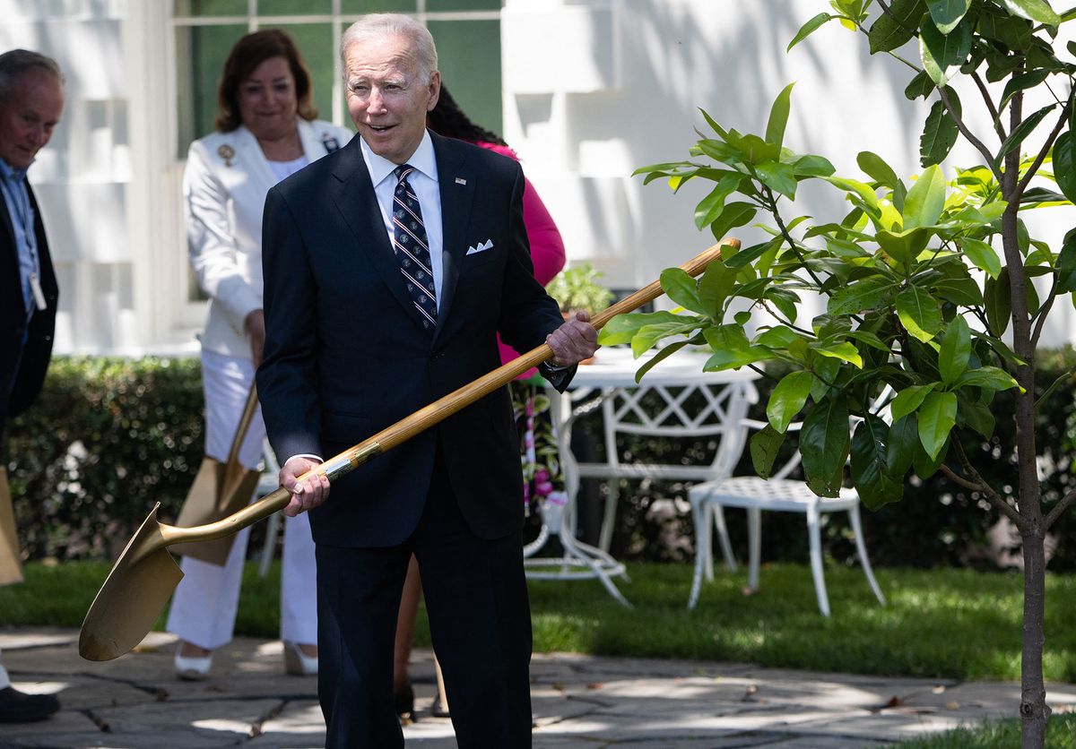 US President Joe Biden holds a shovel as he participates in a tree planting ceremony, along with families of service members who have died, in honor of Memorial Day, on the South Lawn of the White House in Washington, DC, on May 30, 2022. (Photo by SAUL LOEB / AFP)