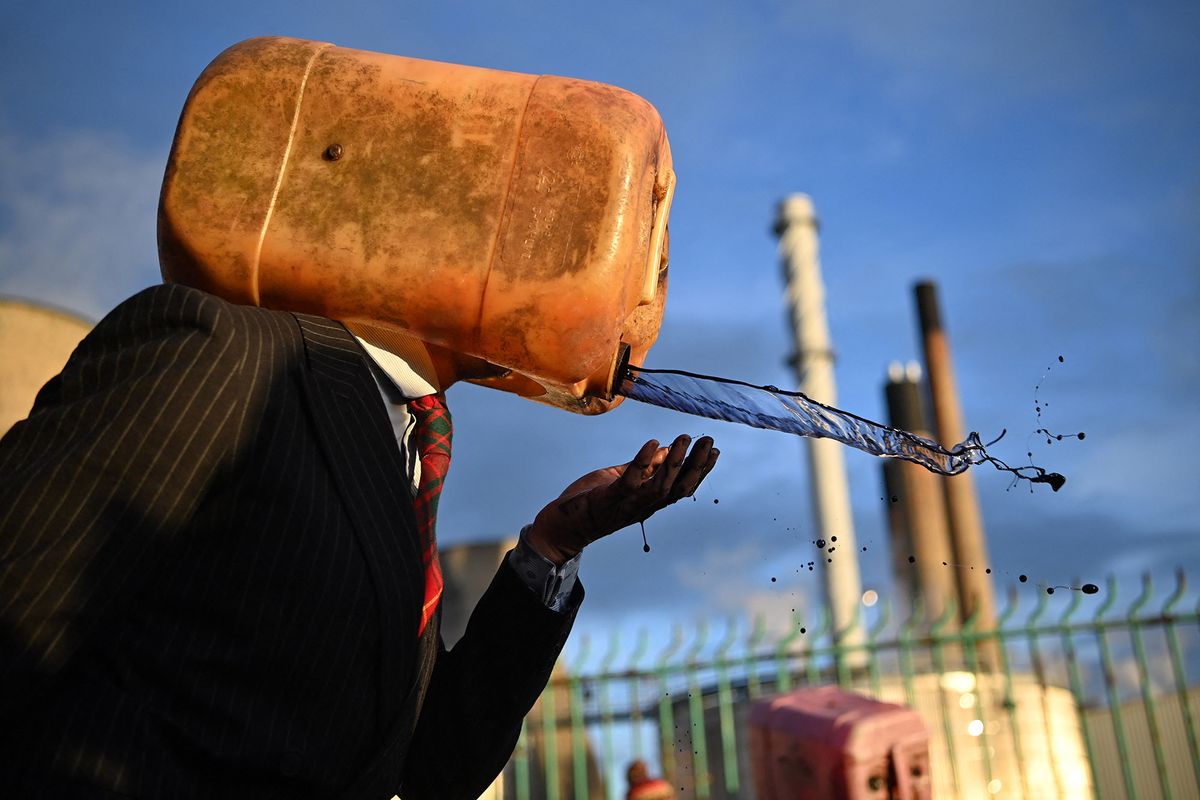 fracking An Oil Head, a climate activist from the Ocean Rebellion group, vomits mock oil as they demonstrate outside the INEOS intergrated refinery and petrochemicals centre plant in Grangemouth, Scotland, during the COP26 UN Climate Change Conference taking place in Glasgow, on November 2, 2021. - World leaders meeting at the COP26 climate summit in Glasgow will issue a multibillion-dollar pledge to end deforestation by 2030 but that date is too distant for campaigners who want action sooner to save the planet's lungs. (Photo by Ben STANSALL / AFP)