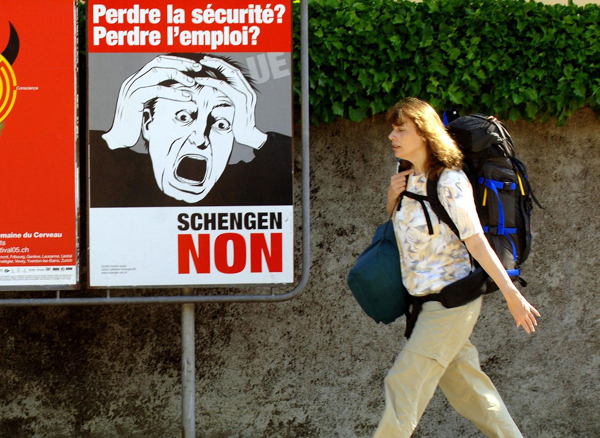 A woman walks by posters for the referendum on the Schengen treaty 27 May 2005, in Nyon. Placard reads: " Lossing security? Loosing job? Schengen NO". AFP PHOTO JEAN-PIERRE CLATOT (Photo by JEAN-PIERRE CLATOT / AFP)
