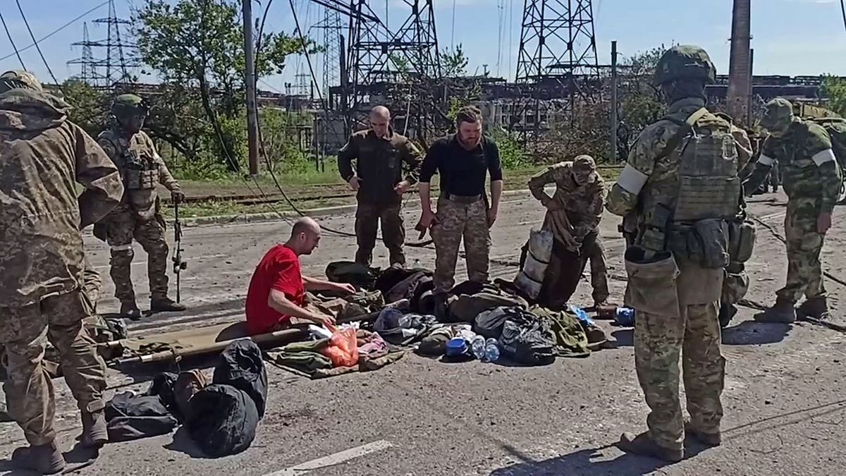 This screen grab obtained from a handout video taken on May 17, 2022 and released by the Russian Defence Ministry on May 18, 2022, shows Ukrainian service members as they are searched by pro-Russian military personnel after leaving the besieged Azovstal steel plant in Ukraine's port city of Mariupol. (Photo by Handout / Russian Defence Ministry / AFP)