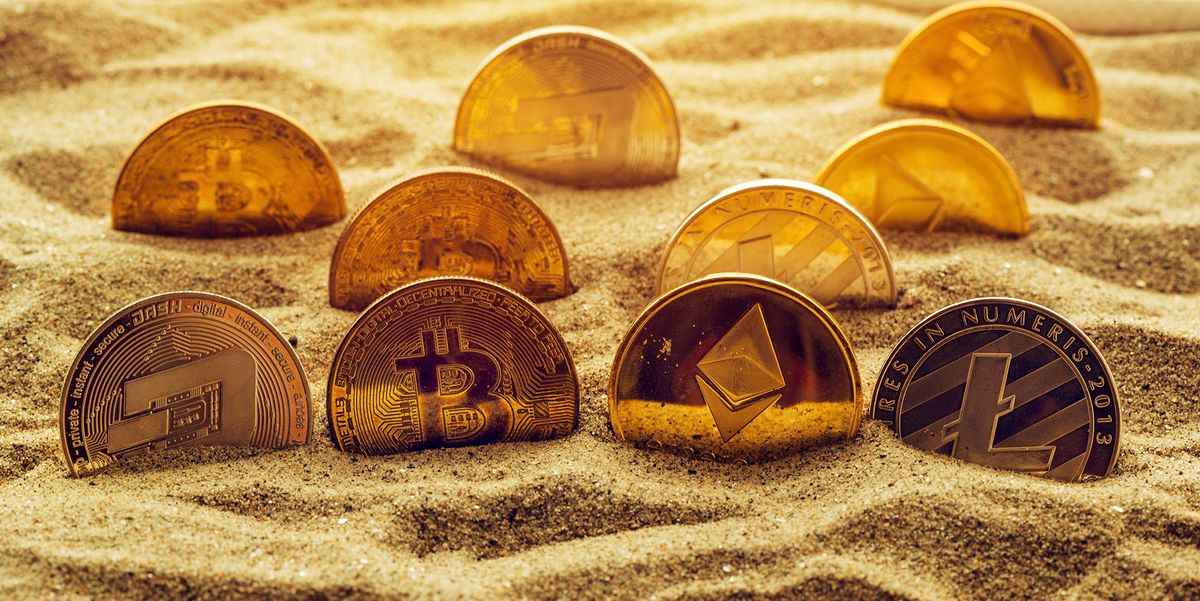 Cryptocurrency coins in sand. Conceptual image for lost and found valuables that are standing the test of time. (Photo by IGOR STEVANOVIC / SCIENCE PHOTO / IST / Science Photo Library via AFP)