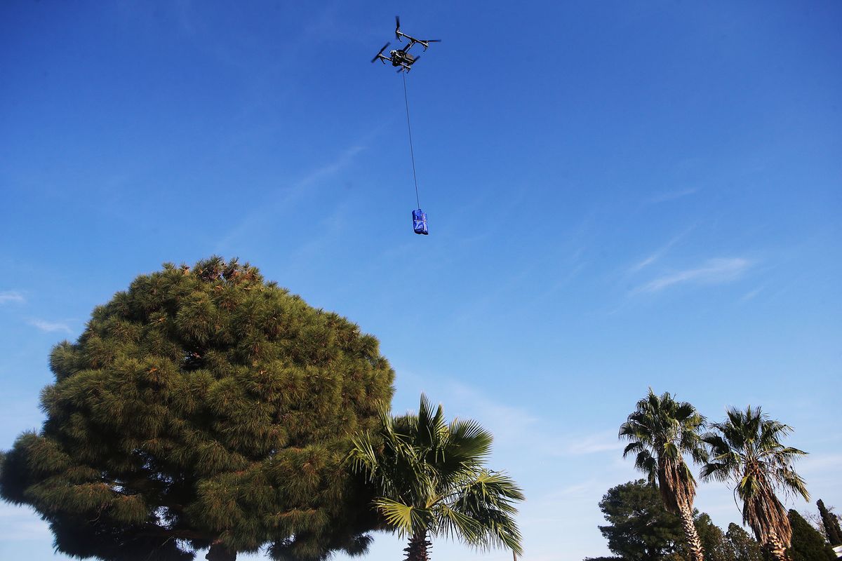 1286783526 EL PASO, TEXAS - NOVEMBER 20: A drone delivers a COVID-19 self collection test kit to a home, after being ordered from Walmart by a resident, amid a Covid-19 surge in El Paso on November 20, 2020 in El Paso, Texas. Residents who live within 1.5 miles of the Walmart Supercenter in East El Paso are eligible for the free kits delivered by DroneUp as part of a drone delivery pilot program. Texas surpassed 20,000 confirmed coronavirus deaths November 16, the second highest in the U.S., with active cases in El Paso now over 35,000 and confirmed COVID-19 deaths at 845. (Photo by Mario Tama/Getty Images)