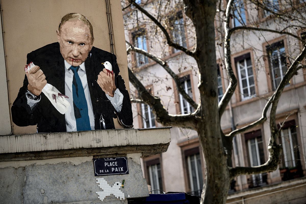 A photo shows a painting depicting Russian President Vladimir Putin killing a dove, at Place de la Paix in Lyon, central eastern France, in March 22, 2022. (Photo by JEFF PACHOUD / AFP)