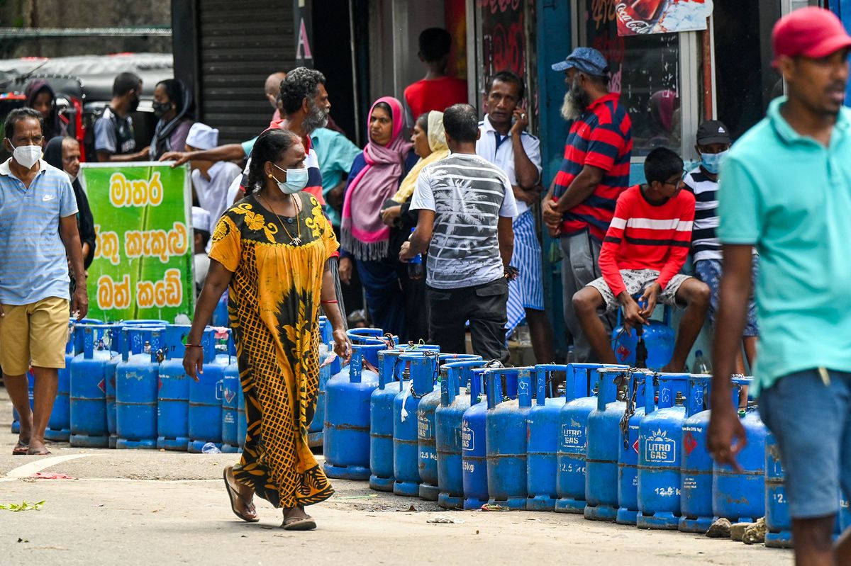 People queue to buy Liquefied Petroleum Gas (LPG) cylinders in Colombo on May 23, 2022. (Photo by ISHARA S. KODIKARA / AFP)