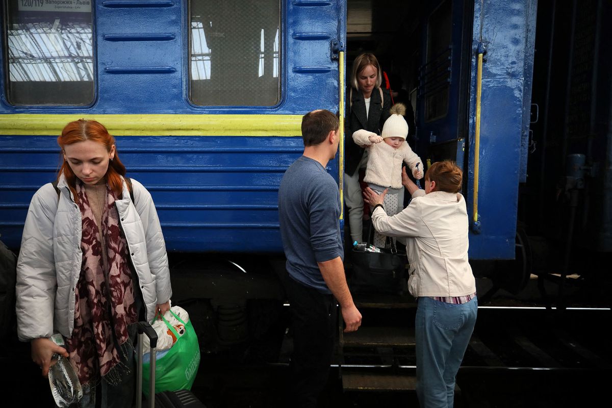 Evacuees from Mariupol disembark from a train arriving from Mariupol, at the railway station of the western Ukrainian city of Lviv, on March 25, 2022, during Russia's military invasion launched on Ukraine. - Ukrainian officials in the strategic port city of Mariupol said on march 25 some 300 people could have died in the previous week's Russian strike on a theatre where hundreds were sheltering. (Photo by Aleksey Filippov / AFP)