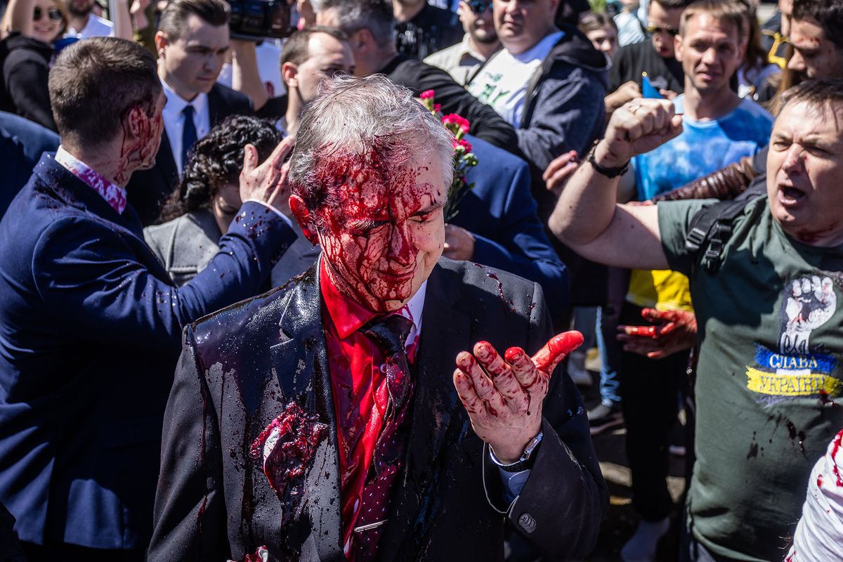 Russian Ambassador to Poland, Ambassador Sergey Andreev reacts after being covered with red paint during a rally for peace in Ukraine in Warsaw, Poland on May 9, 2022, on the day of the 77th anniversary of the 1945 Soviet victory against Nazi Germany. (Photo by Wojtek RADWANSKI / AFP)