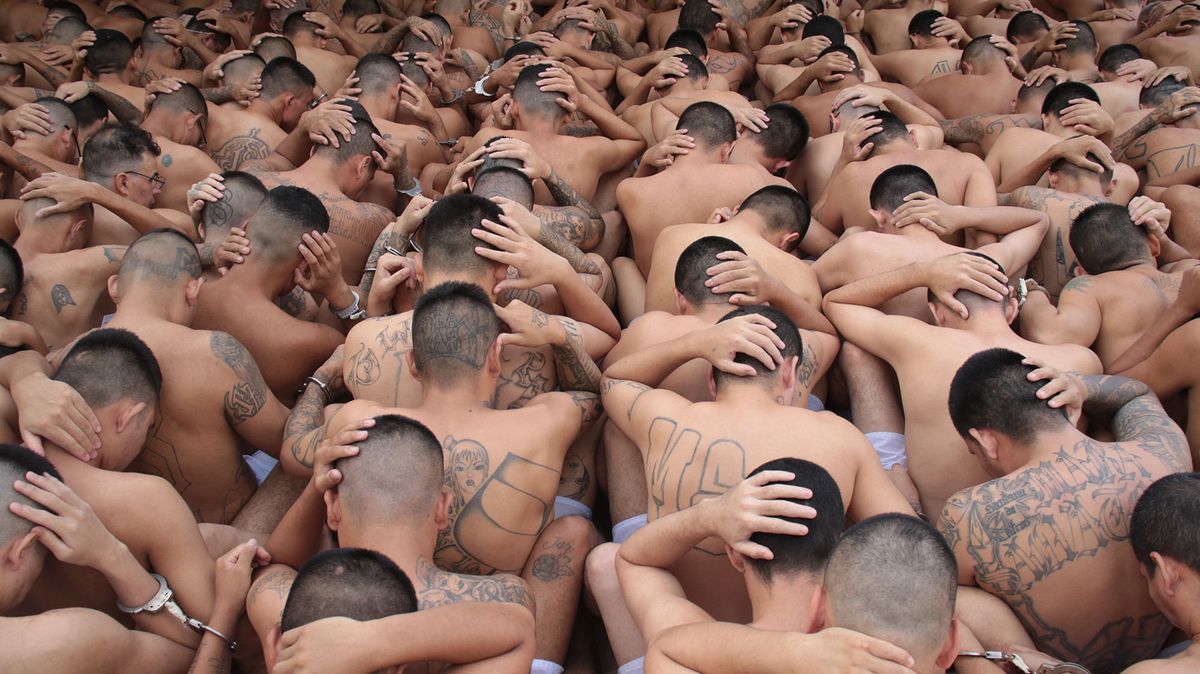 Handout picture released by the press secretary of the Salvadorean Presidency on March 28, 2022 showing members of the Mara Salvatrucha and Barrio 18 gangs under custody during the weekend at the prison in Ciudad Barrios, El Salvador, after the rise in homicide figures that occurred over the past weekend. - El Salvador's President Nayib Bukele issued an ultimatum on March 28, 2022, to gangs considered responsible for dozens of homicides in the ast three days, threatening to increase punishments on their more than 16,000 imprisoned members. The Central American nation declared a state of emergency on Sunday as it endures a fresh wave of gang violence, with police reporting 87 dead since Friday. (Photo by EL SALVADOR'S PRESIDENCY PRESS OFFICE / AFP)