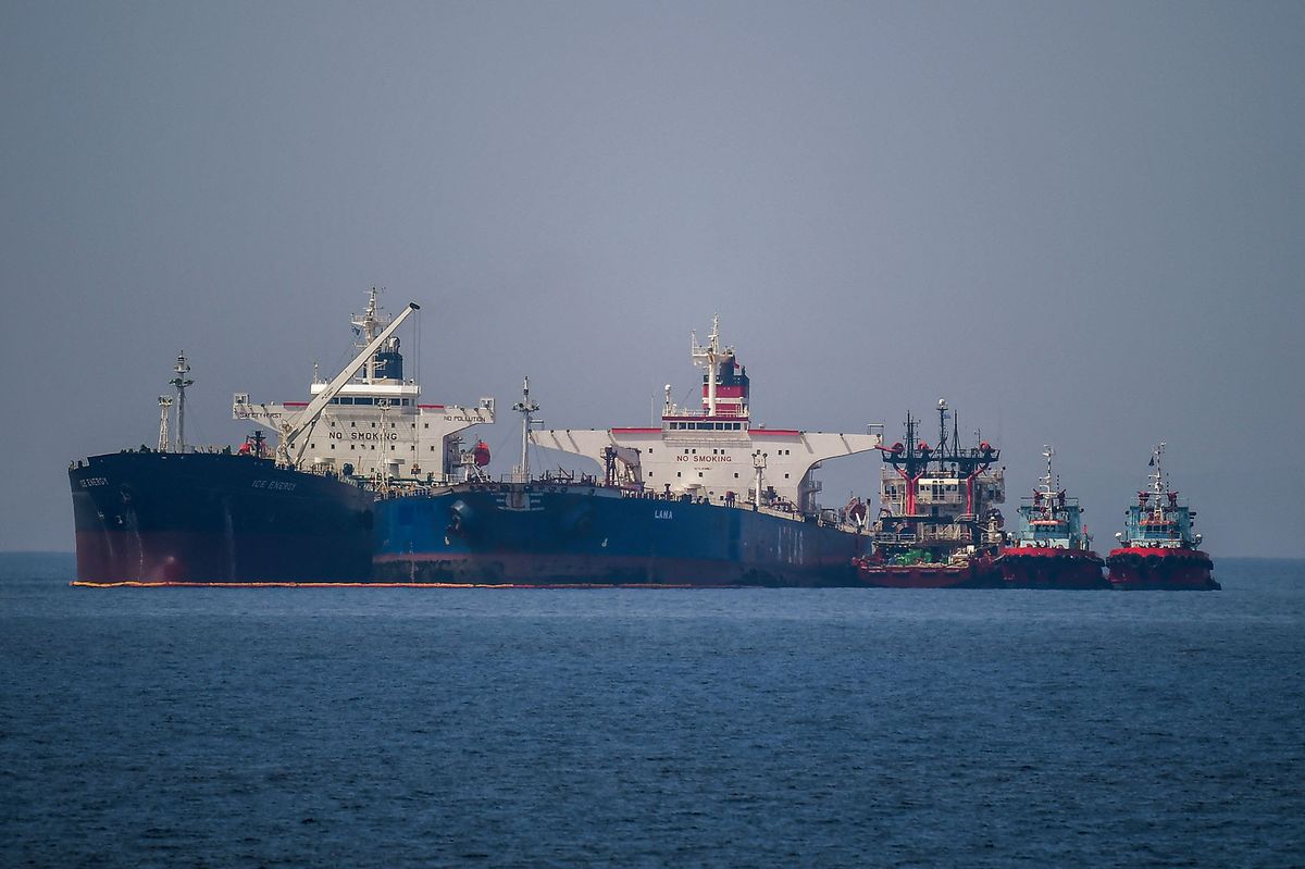 The Liberian-flagged oil tanker Ice Energy (L) transfers crude oil from the Iranian-flagged oil tanker Lana (R) (former Pegas), off the shore of Karystos, on the Island of Evia, on May 29, 2022. - Greece will send Iranian oil from a seized Russian-flagged tanker to the United States at the request of the US judiciary, Greek port police said Wednesday, a decision that angered Tehran. Last month the Greek authorities seized the Pegas, which was said to have been heading to the Marmara terminal in Turkey. The authorities seized the ship in accordance with EU sanctions introduced after Russia invaded Ukraine in February. (Photo by Angelos Tzortzinis / AFP)