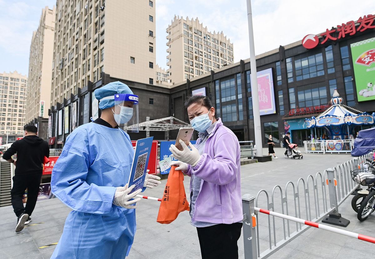 (220510) -- SHANGHAI, May 10, 2022 (Xinhua) -- A resident has her health code checked at the entrance of a supermarket in Jiading District of east China's Shanghai, May 9, 2022. With the number of new infections continuing to go down, retail stores in Shanghai have been gradually returned to normal operation in some areas of the city. (Xinhua/Li He) (Photo by Li He / XINHUA / Xinhua via AFP)