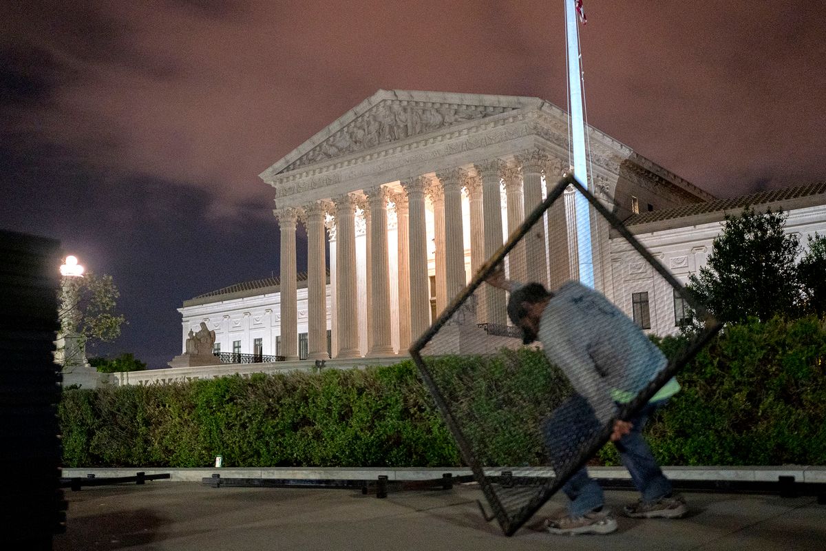 Workers set up un-scalable fencing outside the US Supreme Court in Washington, DC, early on May 5, 2022. - The fencing is being set up due to the protests that have occurred in response to the leaked draft of a majority opinion that would shred nearly 50 years of constitutional protections. The draft, obtained by Politico, was written by Justice Samuel Alito, and has been circulated inside the conservative-dominated court, the news outlet reported. Politico stressed that the document it obtained is a draft and opinions could change. The court is expected to issue a decision by June (Photo by Stefani Reynolds / AFP)