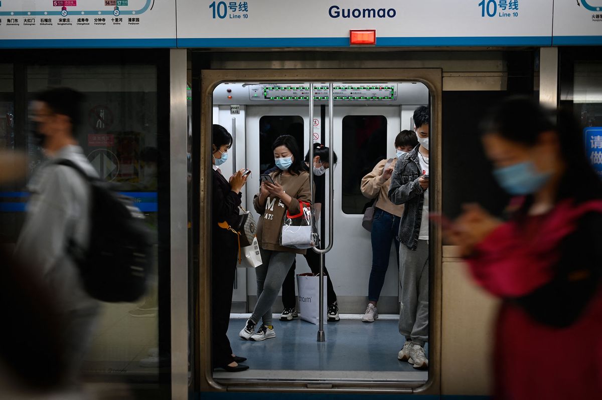 Commuters take a ride on a subway in Beijing on April 18, 2022. (Photo by WANG Zhao / AFP)