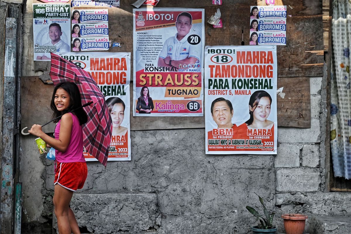 Campaign posters, including one of Philippine presidential candidate Ferdinand Marcos Jr (2nd R), are seen in a slum area in Tondo district in Manila on May 10, 2022. - The son of late Philippine dictator Ferdinand Marcos cemented a landslide presidential election victory on May 10, as Filipinos bet on a familiar dynasty to ease rampant poverty -- dismissing warnings the tarnished clan will deepen corruption and weaken democracy. (Photo by CHAIDEER MAHYUDDIN / AFP)
