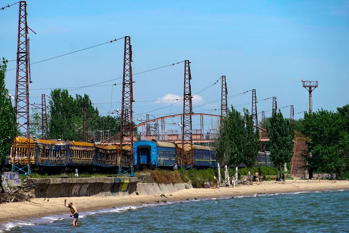 Residents spend time on a shore of the Sea of Azov in Mariupol on May 30, 2022, amid the ongoing Russian military action in Ukraine. (Photo by STRINGER / AFP)