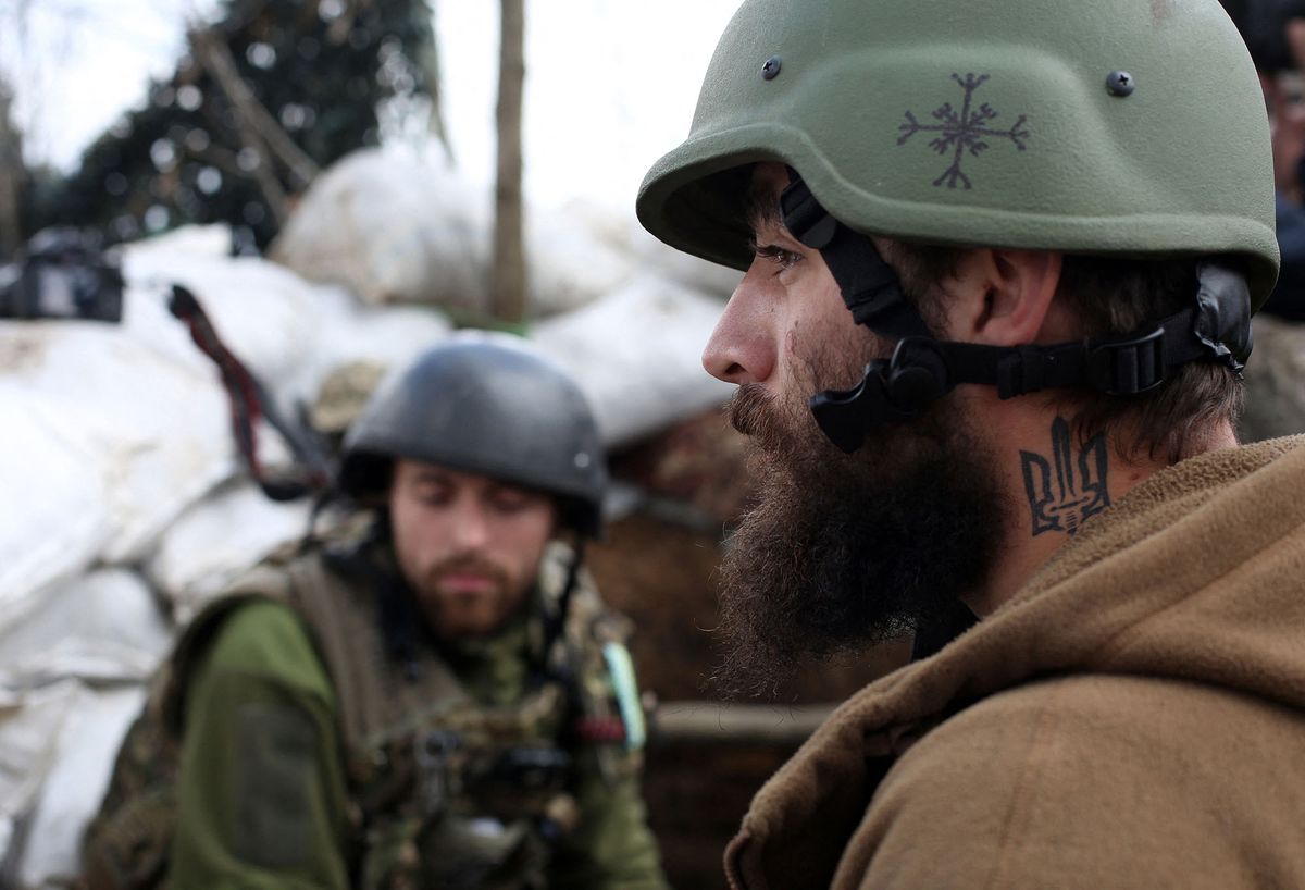 A Ukrainian serviceman with a tattoo of Ukraine's coat of arms stands at his position on the fronline with Russia-backed separatists, not far from Donetsk, on April 22, 2021. - Russia's defence minister ordered an end on April 23 to military drills near Ukraine's border involving tens of thousands of troops and dozens of warships that had exacerbated tensions with the West. The Ukrainian president welcomed the move, saying it reduced tensions after weeks of renewed flighting in the east of the ex-Soviet country between government troops and pro-Moscow separatists. (Photo by Anatolii STEPANOV / AFP)