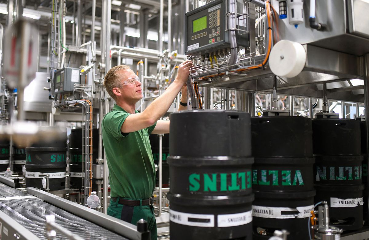 An employee checks the filling of beer kegs at the Veltins brewery in Grevenstein, western Germany on May 9, 2022. - The Veltins brewery in Germany was already wrestling with pandemic-spurred hikes in ingredient and transport costs over the last year, but a surge in energy prices sparked by Russia's invasion of Ukraine threatens to be a bitter pill for the business. (Photo by Ina FASSBENDER / AFP)
