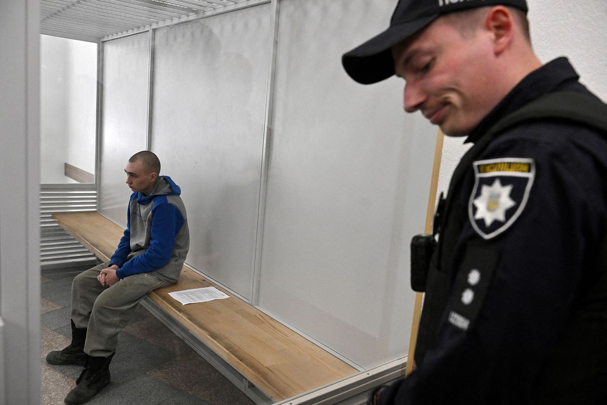 Russian soldier Vadim Shishimarin sits in the defendant's box on the second day of his trial on charges of war crimes for having killed a civilian, at a courthouse in Kyiv on May 19, 2022. - The first Russian soldier on trial for war crimes in Ukraine asked for "forgiveness" in a Kyiv court on May 19 and described how he shot dead a civilian in the opening days of Russia's invasion. Ukrainian prosecutors requested a life sentence. (Photo by Sergei SUPINSKY / AFP)