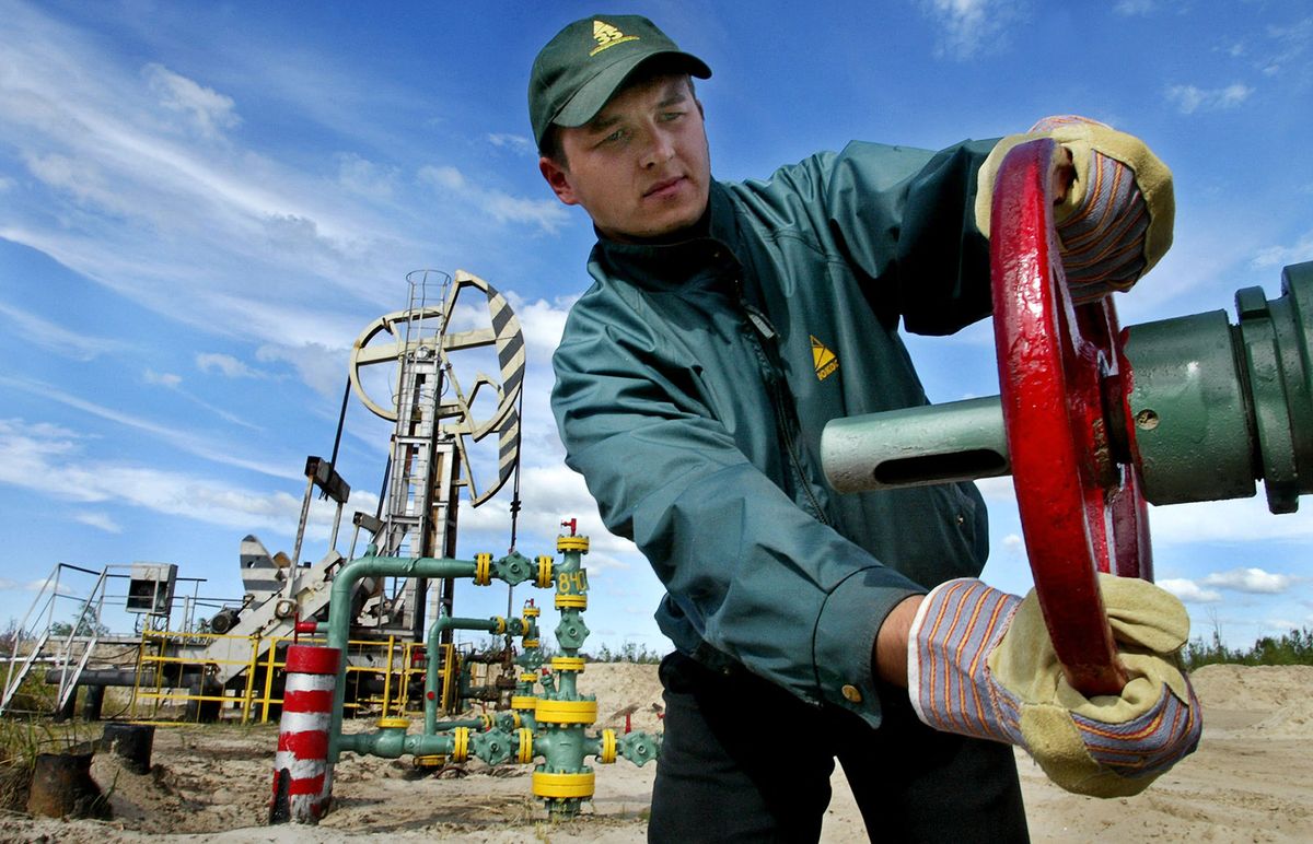 (FILE) A picture taken 04 August 2003 shows an employee of the Russian oil company Yukos turning off a valve at an oil well, in Tyumensk region of Russia. Oil prices climbed 20 September 2004 following reports that Russia's embattled oil giant Yukos has partly suspended deliveries to China and concerns about the impact of Hurricane Ivan on US supplies, traders said. A Yukos spokesman told AFP that the company was suspending deliveries to the China National Petroleum Company, which accounts for some 60 percent of Yukos oil sales to China. AFP PHOTO / ALEXANDER KOROLKOV RUSSIA OUT  MAGAZINE OUT (Photo by ALEXANDER KOROLKOV / AFP)