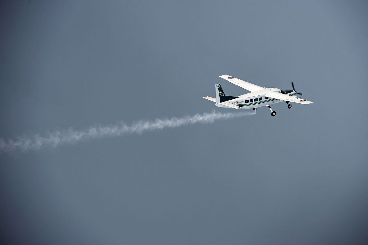 This picture taken on March 25, 2016 shows a pair of Cessna 208 Caravan aircraft from the Thai Department of Royal Rainmaking depositing a sodium chloride-based material above clouds in Nakhon Sawan in an effort to produce rain. - Thailand's prime minister last week told farmers to cultivate less rice to help the country manage its intensifying water crisis, as experts called this year's drought the worst in decades. Water reserves across the country have dipped below last year's levels, which were already considered a record low, according to the irrigation department. (Photo by LILLIAN SUWANRUMPHA / AFP)