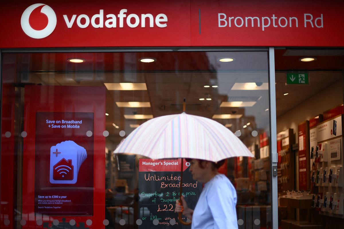A pedestrian passes a Vodafone store in west London on May 15, 2022. (Photo by Daniel LEAL / AFP)