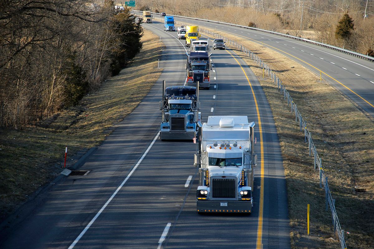 Trucks move along the highway as people gather in support of the Peoples Convoy as it passes various small towns on March 4 2022, in Hagerstown Maryland, USA. The convoy inspired by the Canadian truckers, including the Ottawa Protest, move along Maryland I70 towards the Nations Capital before stopping at the Hagerstown Speedway for two days of organization and regrouping.The truckers demand the end of all COVID-19 mandates. (Photo by John Lamparski/NurPhoto) (Photo by John Lamparski / NurPhoto / NurPhoto via AFP)