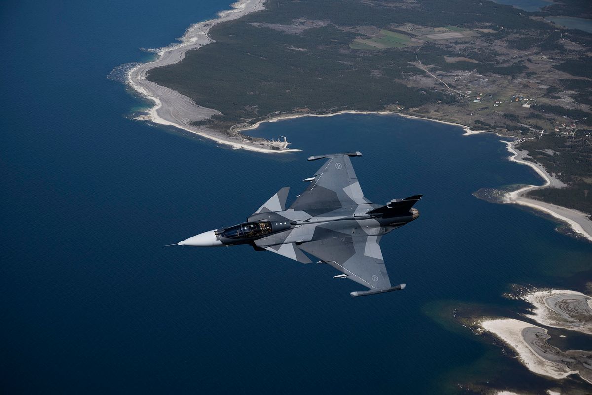 A Swedish airforce Jas 39 Gripen E jet fighter flies over Gotland island in the baltic sea on May 11, 2022. - Sweden will apply for membership in NATO as a deterrent against Russian aggression, Swedish Prime Minister Magdalena Andersson said in a historic reversal of the country's decades-long military non-alignment. (Photo by Henrik MONTGOMERY / various sources / AFP) / Sweden OUT