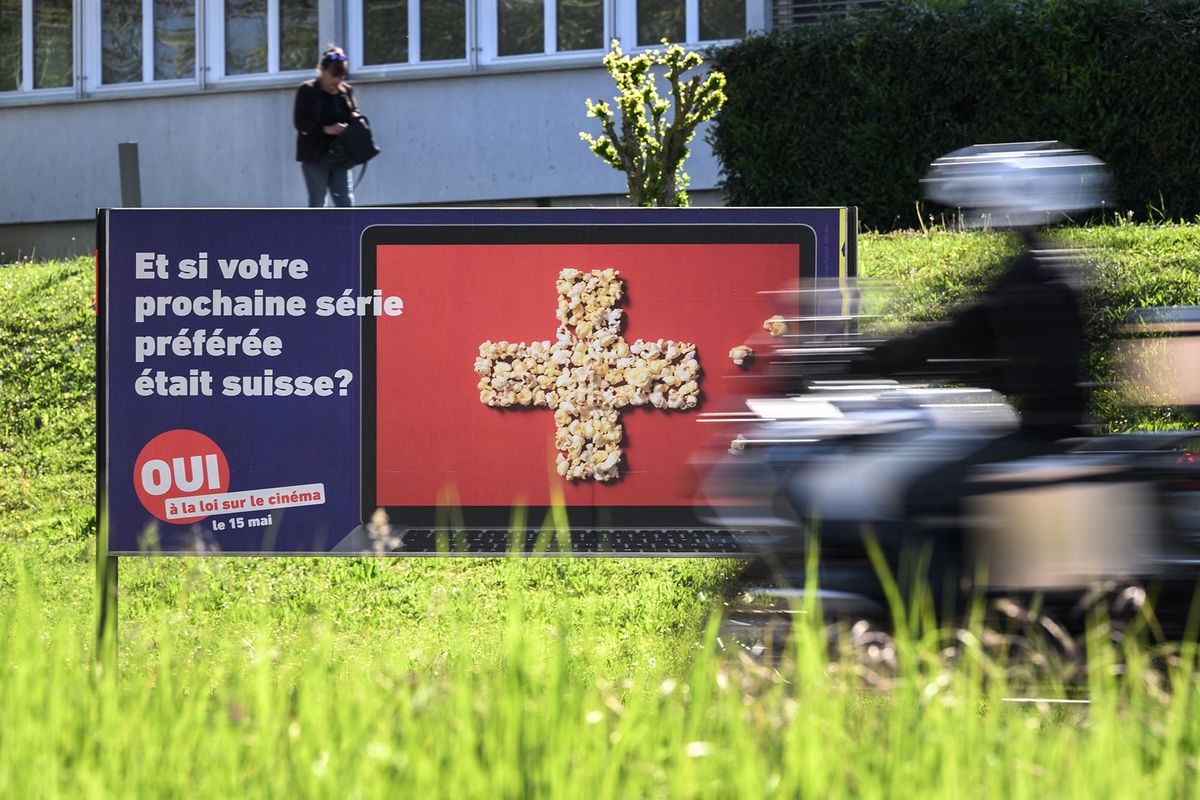 This photograph shows an electoral placard in favor of a law being voted by Swiss citizen on May 15, 2022 to oblige streaming services to invest in domestic production in Yverdon, on May 11, 2022. - Switzerland may not top the list for internationally-renowned films, but a law being voted on May 15, 2022 seeks to change that by forcing streaming services to invest in local movie-making. The so-called "Lex Netflix" referendum looks set to pass by a narrow margin, according to recent opinion polls. (Photo by Fabrice COFFRINI / AFP)