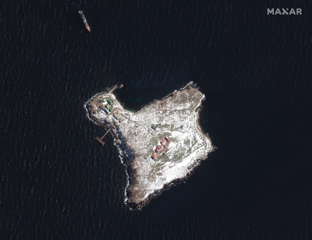 This Maxar satellite image taken on March 13, 2022 and released on March 14, 2022 shows a Russian Ropucha-class ship anchored near Snake Island (Zmiinyi Island) and damage to some of the buildings (C) on the island. - Russia seized Snake Island in late February, an uninhabited but strategic rocky outcrop just 45 kilometres from Romania's coast where Bucharest has offshore gas reserves. (Photo by Satellite image ©2022 Maxar Technologies / AFP)