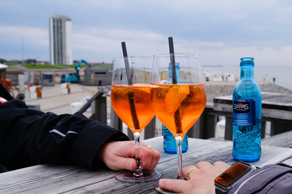 10 May 2021, Schleswig-Holstein, B¸sum: Two holidaymakers toast with their drinks glasses. As the fourth and last model region in Schleswig-Holstein, B¸sum started the tourism season on 10 May 2021. In the North Sea resort in the district of Dithmarschen, guests can once again spend their holidays under strict corona protection regulations. Photo: Frank Molter/dpa (Photo by FRANK MOLTER / DPA / dpa Picture-Alliance via AFP)