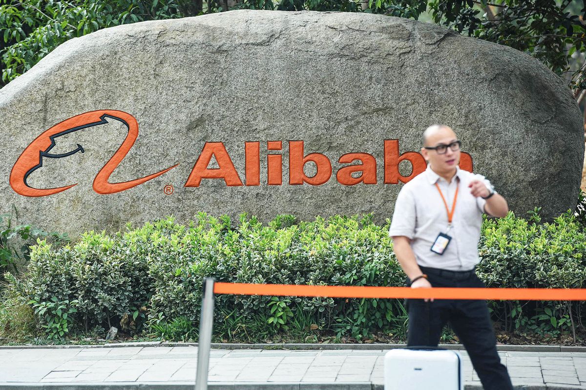 A staff member walks past a logo of Chinese e-commerce giant Alibaba in its headquarters in Hangzhou in China's eastern Zhejiang province on May 27, 2022. (Photo by AFP) / China OUT