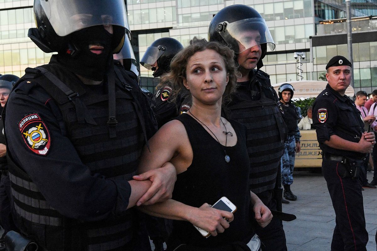 (FILES) In this file photo taken on July 27, 2019 police officers detain political activist Maria Alyokhina during an unauthorised rally demanding independent and opposition candidates be allowed to run for office in local election in September, at Moscow's Trubnaya Square. - Pussy Riot member Maria Alyokhina has left Russia, she said in an interview, after disguising herself as a food delivery courier to escape police. Alyokhina joins thousands of Russians that have fled their country since President Vladimir Putin sent troops into Ukraine on February 24. (Photo by Kirill KUDRYAVTSEV / AFP)