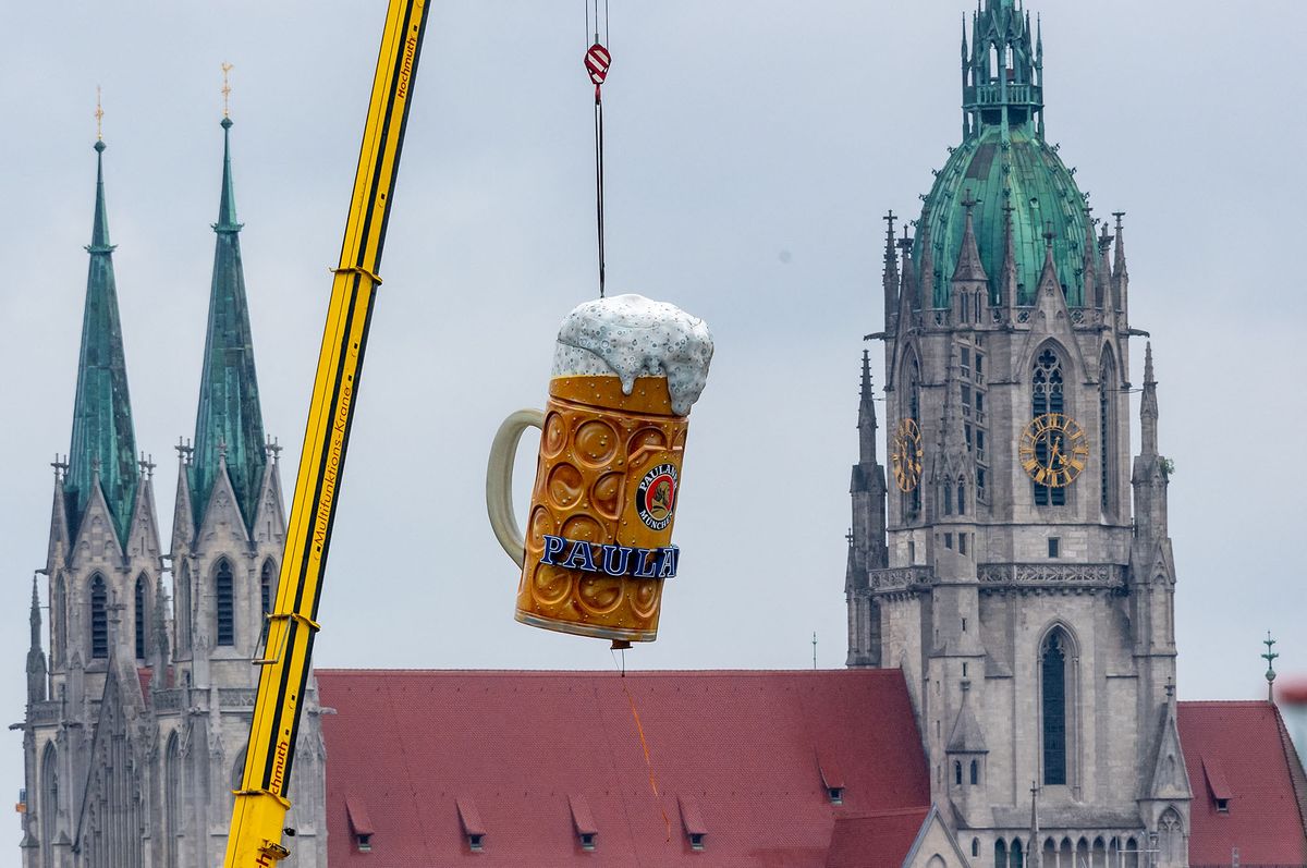 11 July 2019, Bavaria, Munich: An oversized beer mug weighing around 1.5 tons is lifted to its place by a crane on the Theresienwiese. In the background you can see the Sankt Paul church. The Oktoberfest starts this year on 21 September and ends on 06 October. Photo: Peter Kneffel/dpa (Photo by PETER KNEFFEL / DPA / dpa Picture-Alliance via AFP)