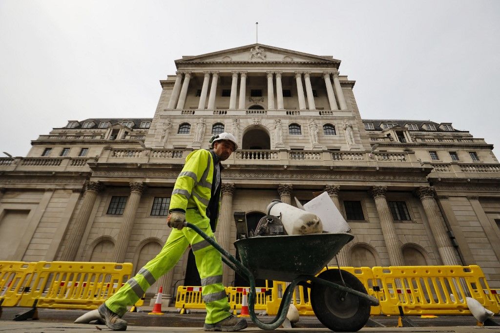 A worker pushes a wheelbarrow of debris outside the Bank of England in London on June 17, 2020. - The Bank of England, confronted by Britain's collapsing coronavirus-ravaged economy, will on June 18 reveal the outcome of its latest monetary policy meeting with analysts predicting more stimulus. The British central bank has been at the forefront of economic fire-fighting over this year's deadly COVID-19 emergency -- and could expand its quantitative easing (QE) stimulus in an attempt to kickstart growth. (Photo by Tolga Akmen / AFP)