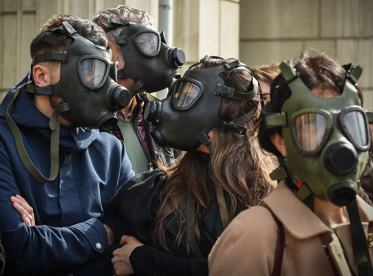 Protesters wear gas masks in the front of the Romanian Environment Ministry in Bucharest March 4, 2019, to demand better air. - Dozens of people holding placards reading "Our children don't breath air anymore" gather in the front of the Environment Ministry to ask for better breathable air in Bucharest. (Photo by Daniel MIHAILESCU / AFP)