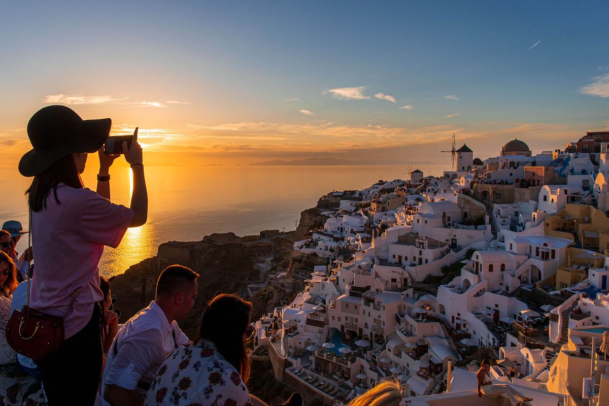 Greece, Cyclades Archipelago, Santorini Island in the Aegean Sea. Clinging to the cliff, overlooking an underwater caldera (crater), the village of Oia attracts tourists from all over the island to watch the traditional sunset (Photo by Alizee Palomba / ONLY WORLD / Only France via AFP)