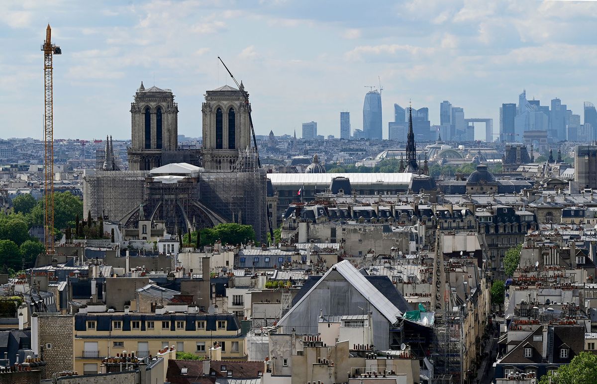 A photograph shows a view of Notre-Dame cathedral and La Defence business district from the rooftop restaurant at the Morland Mixite Capitale complex, a new mixed used real estate complex in the heart of Paris on May 5, 2022. - The complex which is opening in 2022 features appartments, a hotel, a roof top restaurant and bar, retails shops, restaurants, a nursery, offices, a youth hostel, a gym with swimming pool, an art galery and a rooftop vegetable garden. (Photo by Emmanuel DUNAND / AFP)